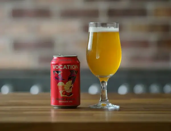 Czerwona puszka piwa Vocation Heart & Soul Session IPA z napisem "Gluten Free" obok szklanki z bursztynowym piwem. To piwo nie ma glutenu.